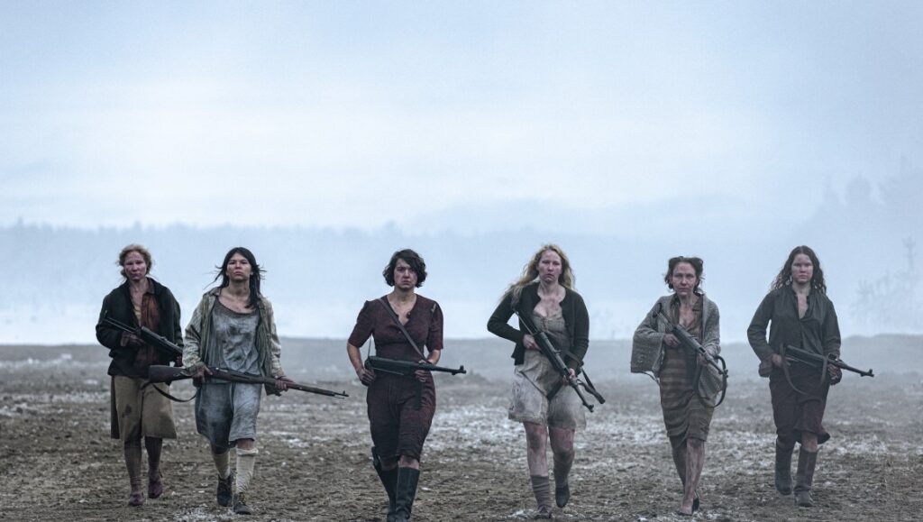 Sisu movie still: Women warriors march with rifles. War film scene.
