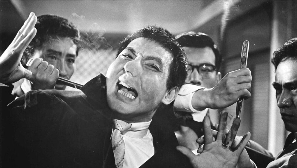 Youth of the Beast scene. Japanese Yakuza movie. Black and white film still. Man being attacked.