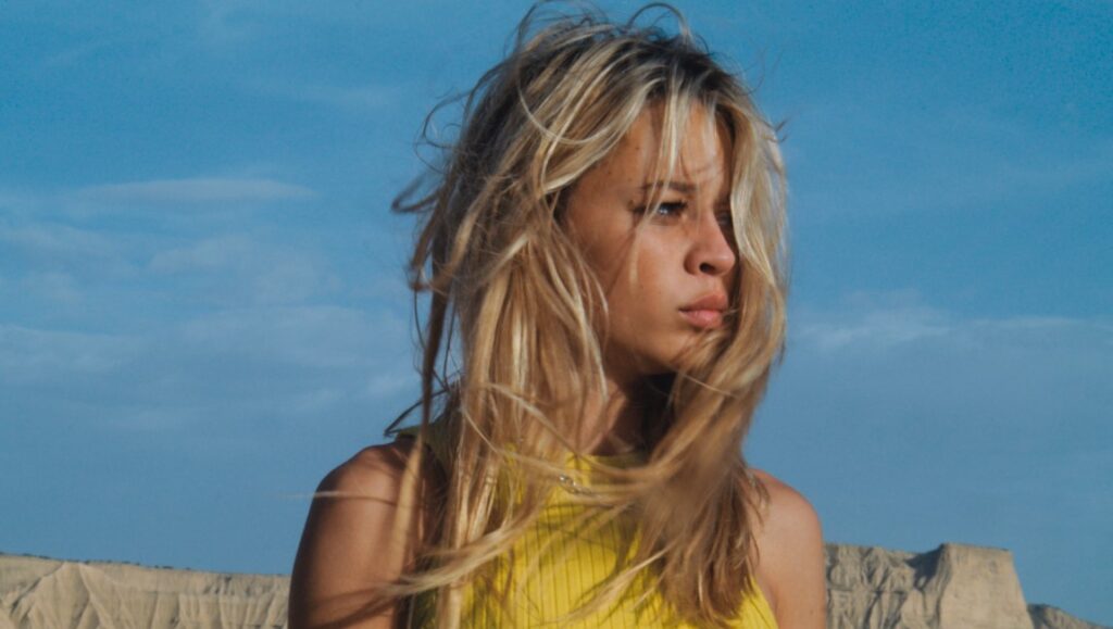 The Other Laurens movie still. Blonde woman, yellow top, blue sky. Claude Schmitz film review.