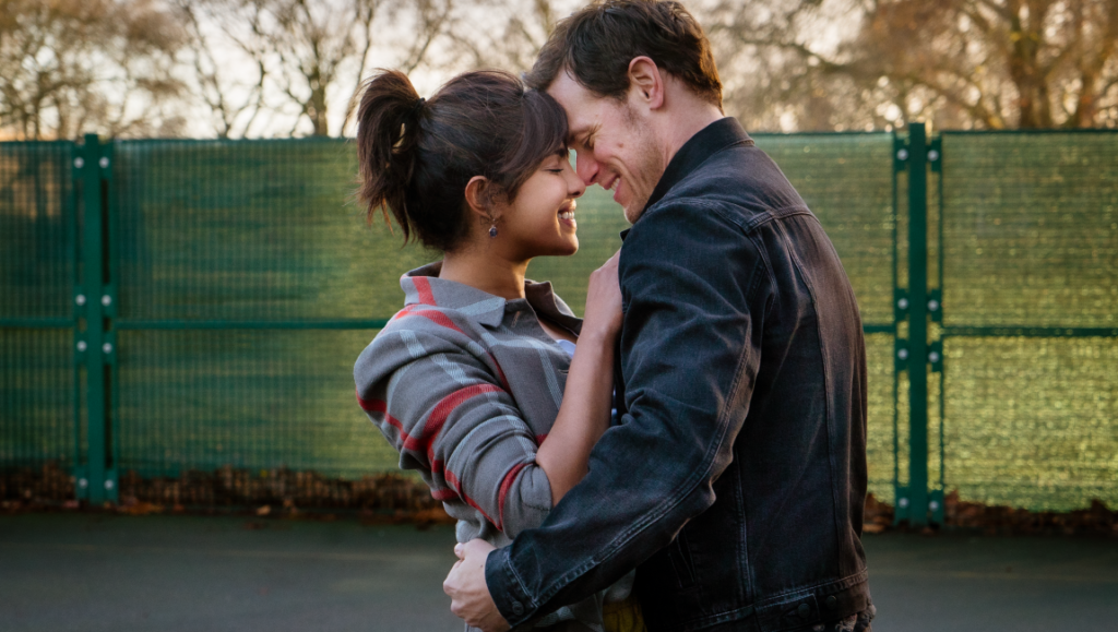 Priyanka Chopra and Sam Heughan in Love Again movie. Romantic comedy film scene of a couple embracing.