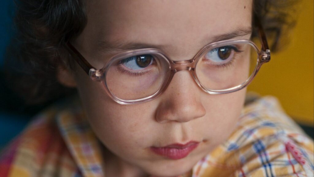 Close-up of young girl with glasses in Ama Gloria, Marie Amachoukeli-Barsacq film. Cannes '23 review.