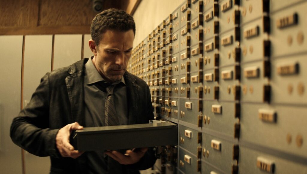 Hypnotic — Robert Rodriguez Ben Affleck in Hypnotic movie. He is holding a box in a room full of safety deposit boxes.