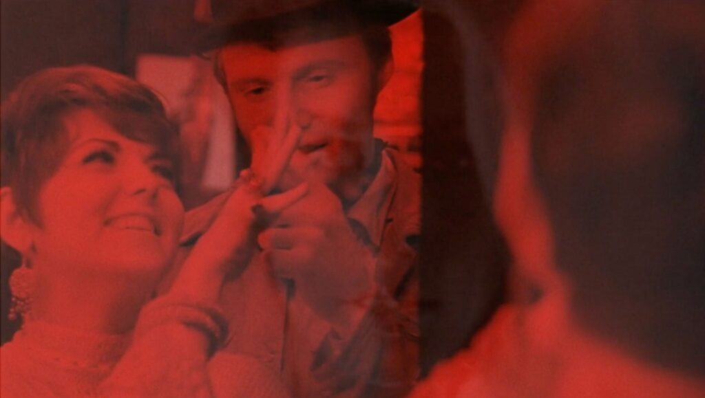 Desperate Souls, Dark City and the Legend of Midnight Cowboy — Nancy Buirski Desperate Souls movie scene. Woman smiles at a man with a hat, red filter. Kino Lorber film.