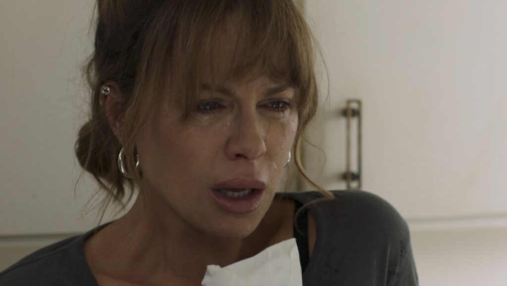 Prisoner’s Daughter — Catherine Hardwicke Woman crying. Close-up of a distressed woman with tears on her face, holding a tissue. Emotional scene.