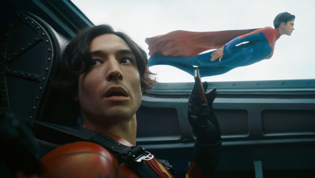 Ezra Miller as The Flash and Supergirl flying in the movie The Flash (2023).