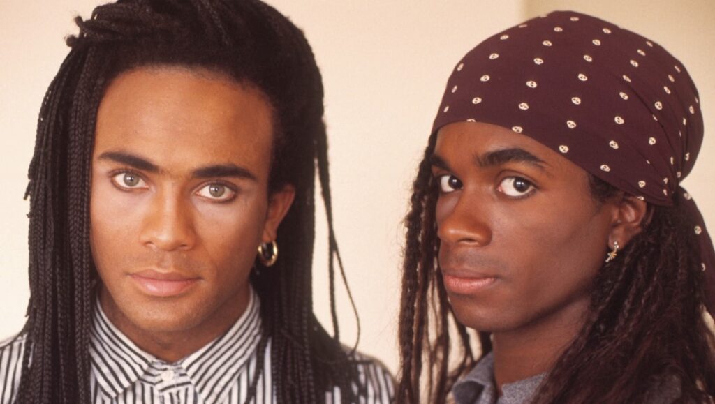 Milli Vanilli, the 80s pop duo, in a promotional shot. Braids, headscarf, eyeliner.