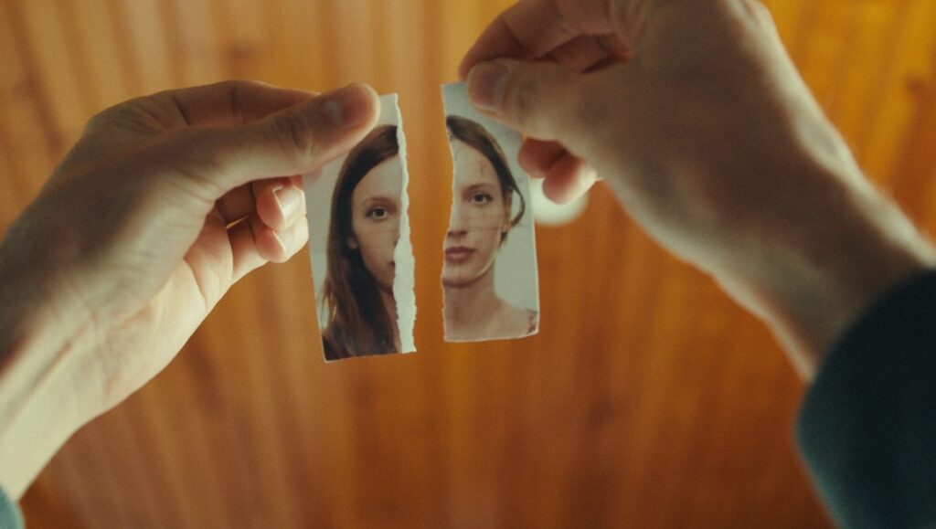 No Love Lost movie still. Hands tear a photo of a woman in two. Cannes '23 film review.