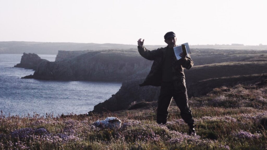 New World! (The World Anew) film still. Man on cliff overlooking ocean. FIDMarseille '23 review.