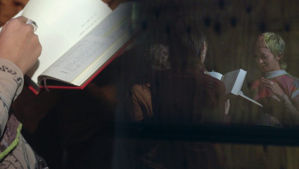 Two women reading books. One has dyed hair. Of Girls (KANOJO-TACHI-scaled) title.