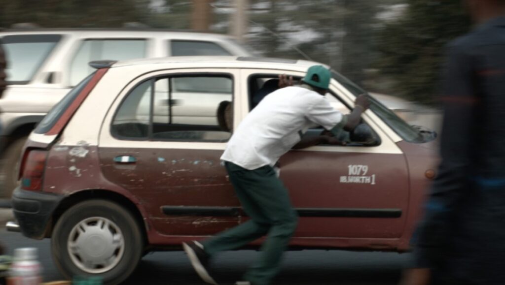 Man entering a brown and white taxi cab. Urban transport scene.