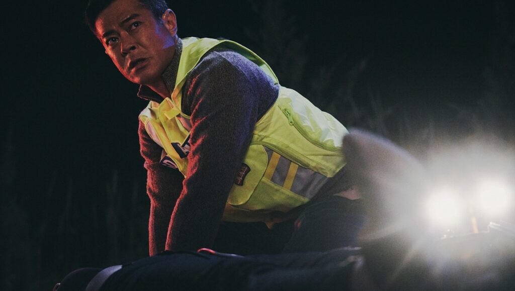 Still from Vital Signs at NY Asian Film Festival. Man in vest leans over another person.