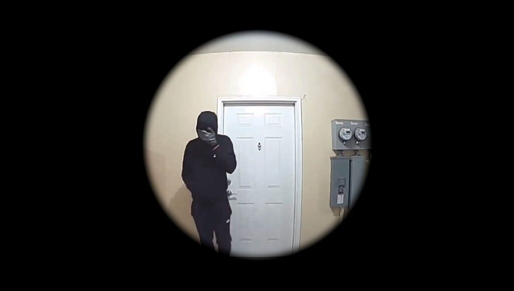 Home invasion scene. Burglar in black at door, viewed through peephole. Fantasia Fest film River review.