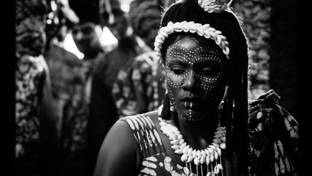 Mami Wata — C.J. Obasi Black and white still from Mami Wata at Fantasia Fest. Woman with face paint, shells.