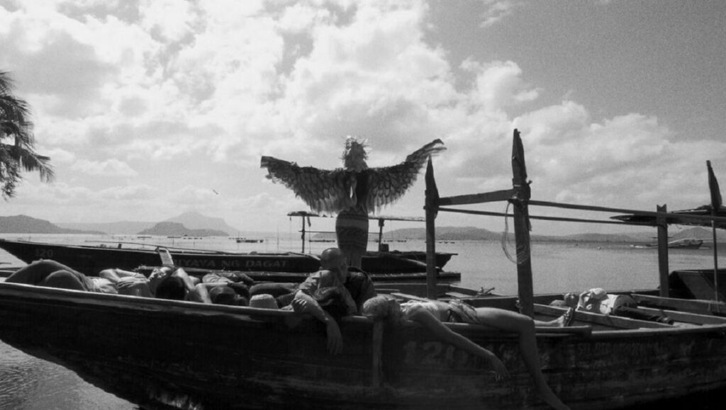 Locarno Film Festival 2023 — Dispatch 2: Essential Truths of the Lake, The Old Oak, Lousy Carter Black and white film still from Locarno Film Festival: People in boats, one with wings.