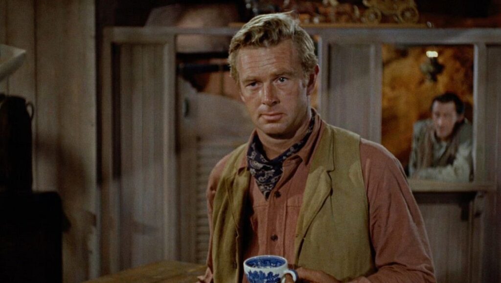 Johnny Guitar film still. Nicholas Ray directs a scene with actor, coffee cup, and bandana. Western movie.