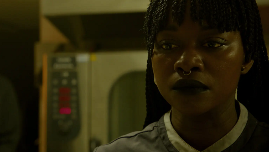 Our Father, the Devil film still. Woman with braids, nose ring, and dark lipstick. Ellie Foumbi movie.