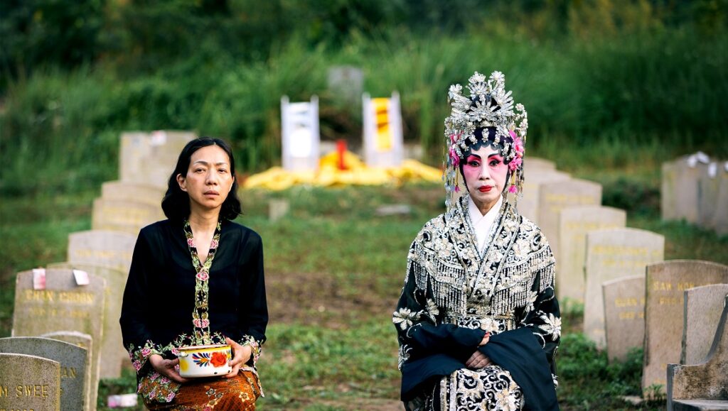 Still from Snow in Midsummer at Venice Film Festival 2023. Two women in a graveyard.