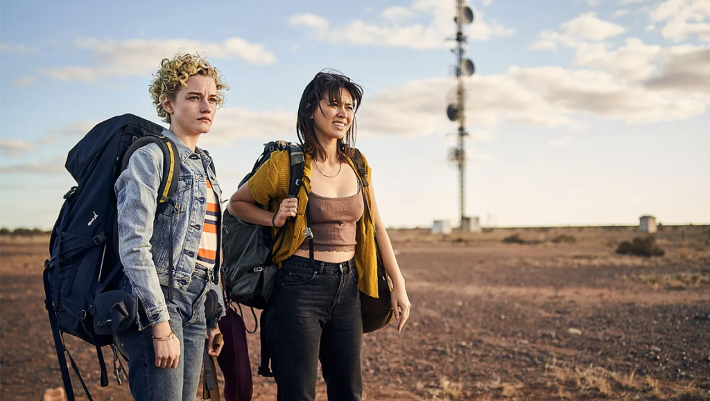 The Royal Hotel movie still: Two backpackers in the Australian outback, near a communication tower.