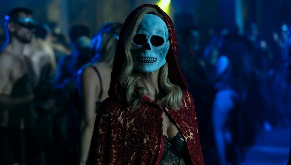 The Fall of the House of Usher — Mike Flanagan The Fall of the House of Usher: Woman in skull mask and red hooded cape at a party.