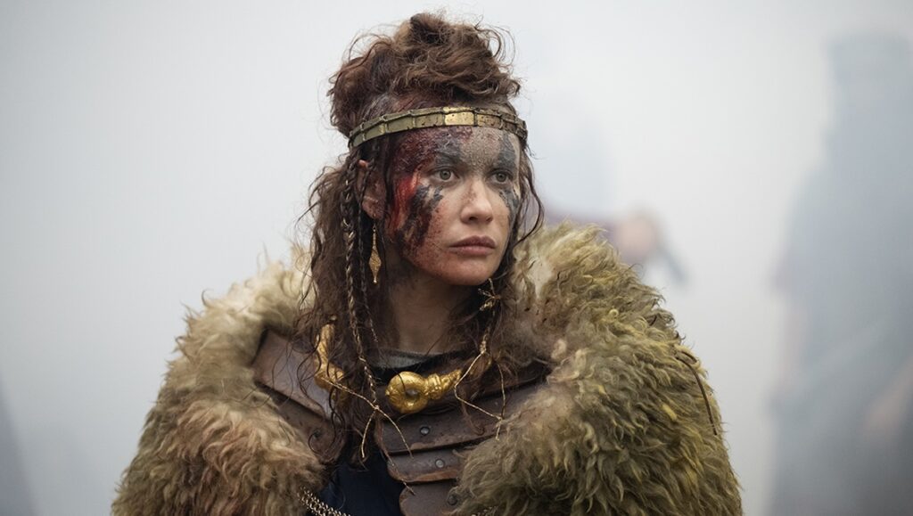 Boudica: Queen of War. Celtic warrior with face paint, fur cloak, and gold jewelry. Strong female leader.