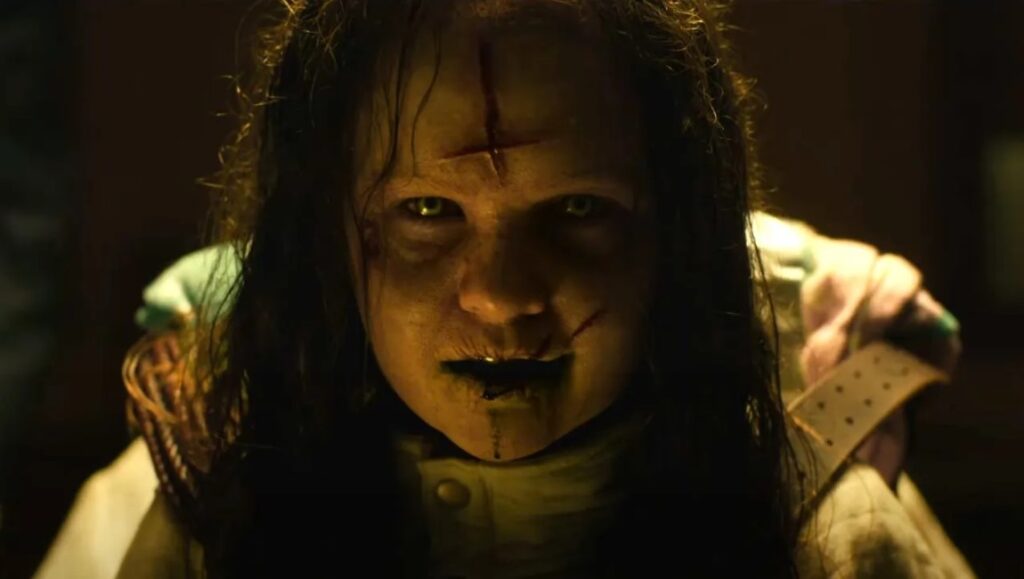 The Exorcist: Believer movie still. Demonic possessed girl with bloody cross on forehead. Horror film.