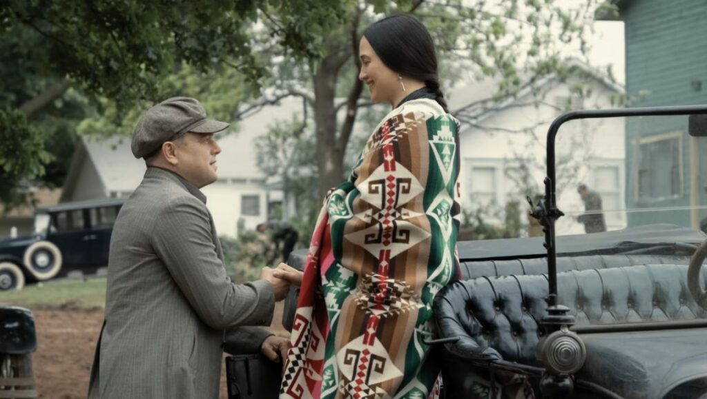 Killers of the Flower Moon film still. Leonardo DiCaprio and Lily Gladstone in a scene.