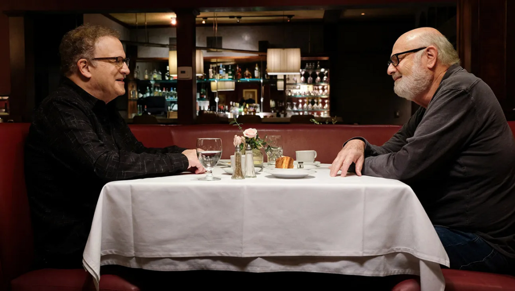 Albert Brooks and Rob Reiner at dinner in Defending My Life documentary.