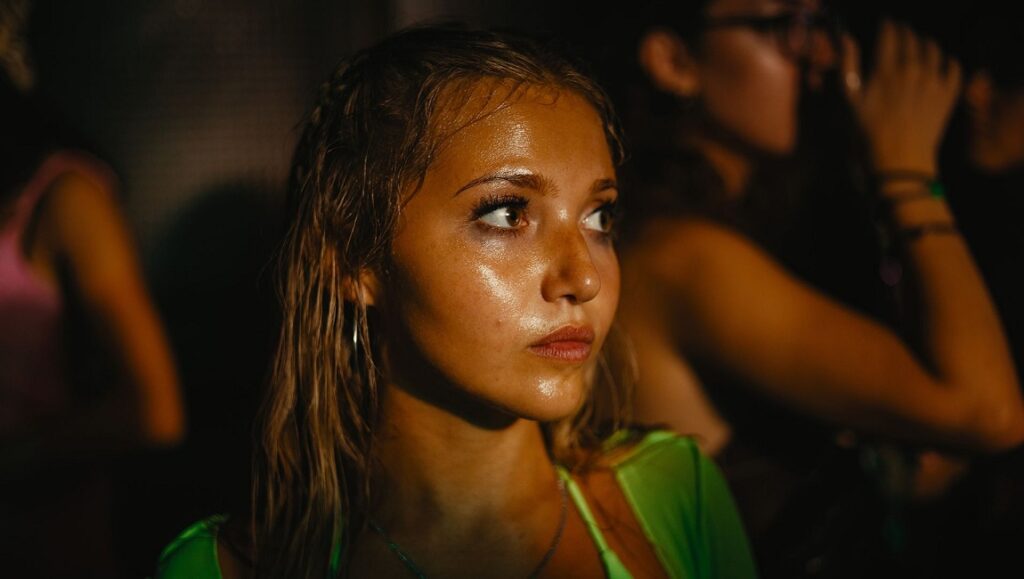 How to Have Sex movie still. Teen girl at a party, looking concerned. Molly Manning Walker film review.