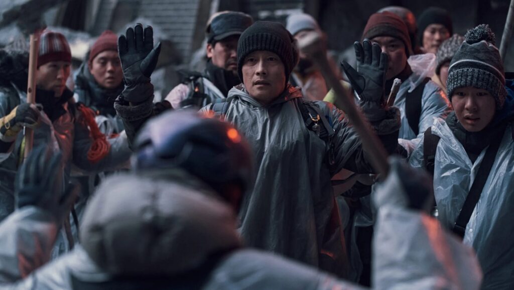 Concrete Utopia — Um Tae-hwa Concrete Utopia film scene. Crowd with hands up. Um Tae-hwa movie.