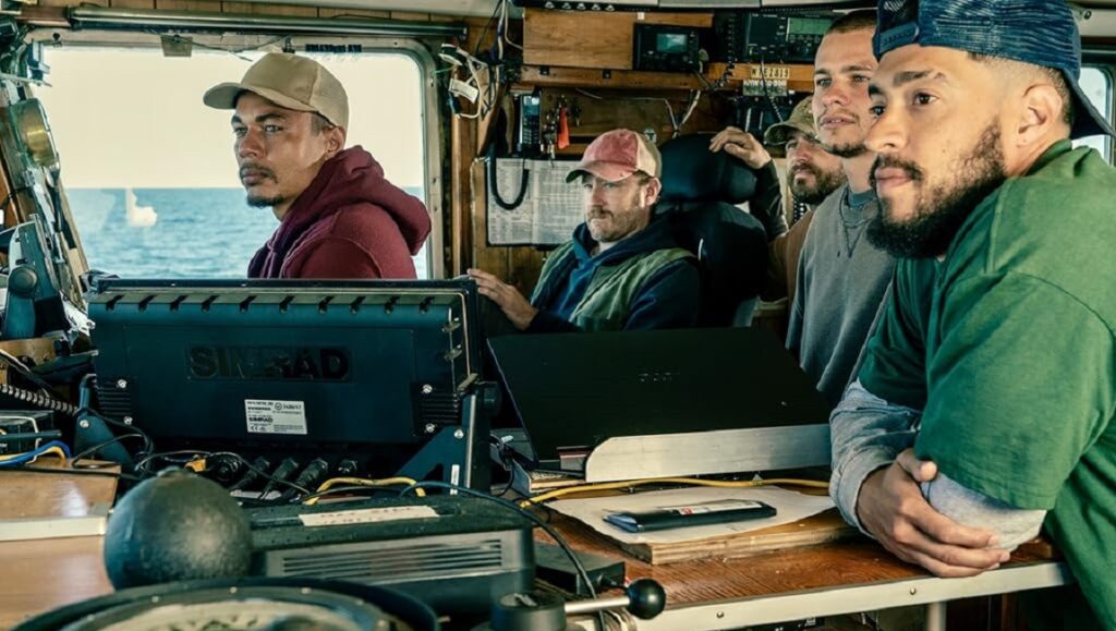 Finestkind — Brian Helgeland Finestkind movie scene. Crew on a fishing boat, looking ahead. Ben Foster stars in the crime thriller.