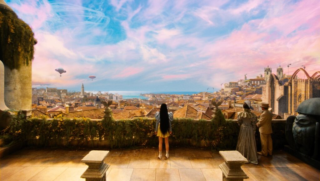 Poor Things — Yorgos Lanthimos Poor Things movie scene: Bella Baxter overlooking a fantastical city with airships and vibrant sky.