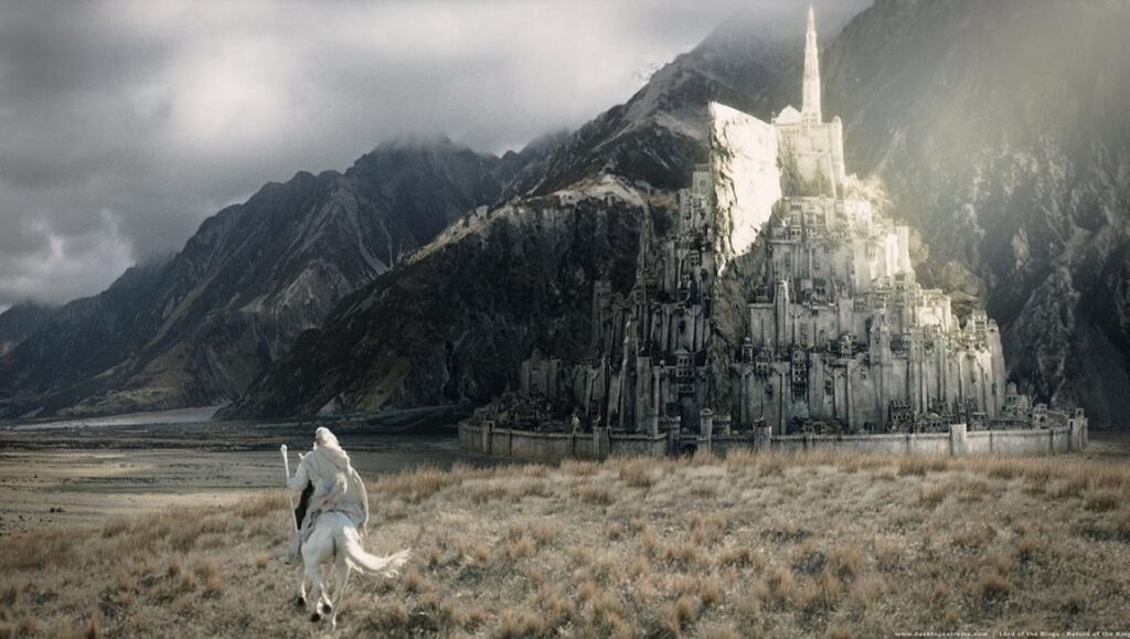 Lord of the Rings: The Return of the King scene. Gandalf riding toward Minas Tirith, the white city, with mountains.
