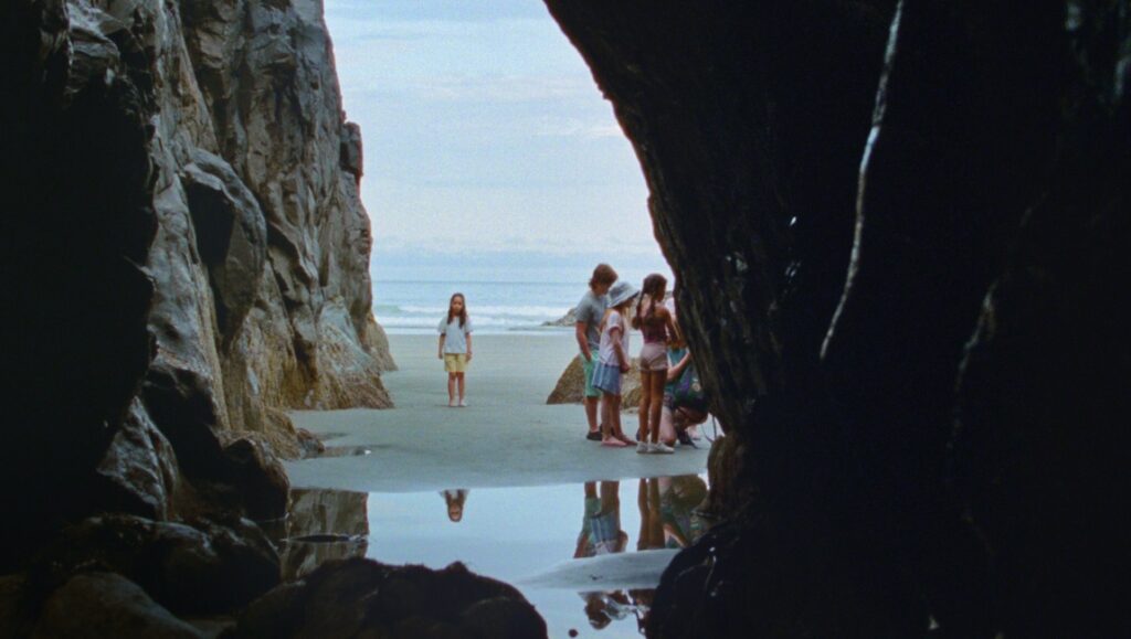 Seagrass movie scene: Children on beach seen from cave. Meredith Hama-Brown film review.
