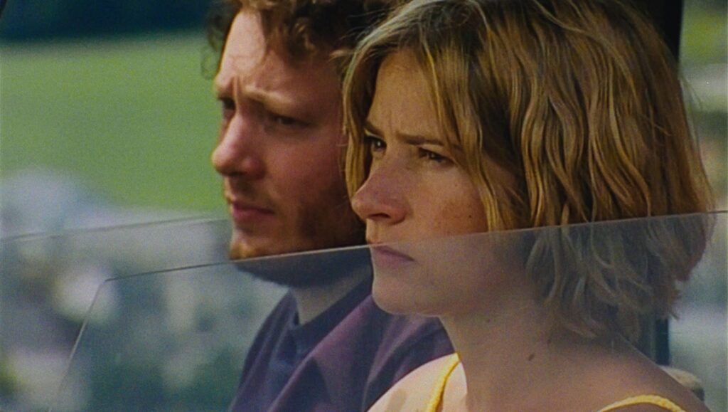 Still from Gasoline Rainbow movie. Arthur and Diana look out of a car window. Bill Ross & Turner Ross film review.