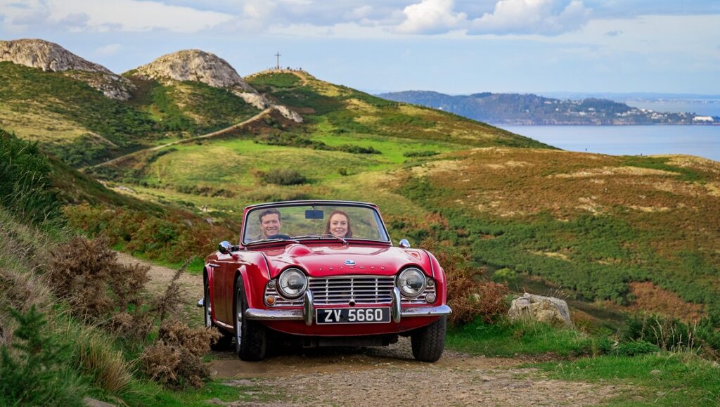 Irish Wish movie scene: Lindsay Lohan in a red convertible car, scenic Irish landscape.