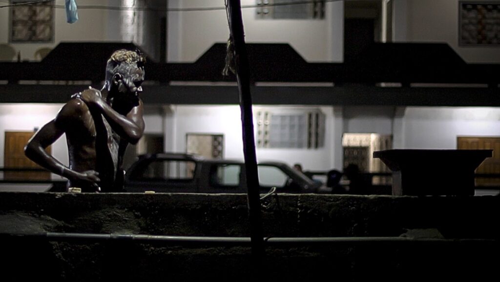 Still from Gasoline Rainbow review: Man washing in the dark. Bill Ross and Turner Ross film.