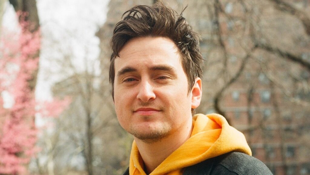 In the Future We Would Splurge for Some Lotted Parking: An Interview with Ryan Martin Brown Ryan Martin Brown portrait. Interview with the artist in a yellow hoodie.