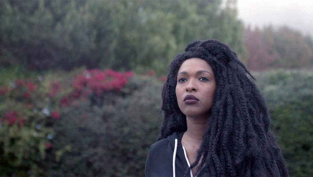 Alison O'Daniel's The Tuba Thieves review: Deaf actress with braids, wearing a hoodie, looks off-camera.