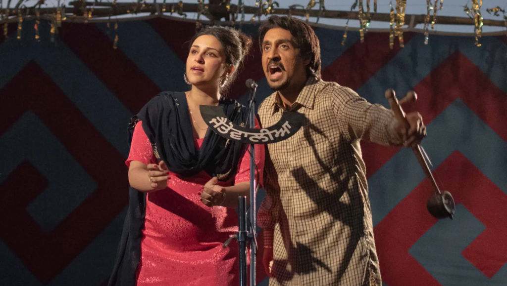 Amar Singh Chamkila movie still. Parineeti Chopra and Diljit Dosanjh perform on stage. Imtiaz Ali film.