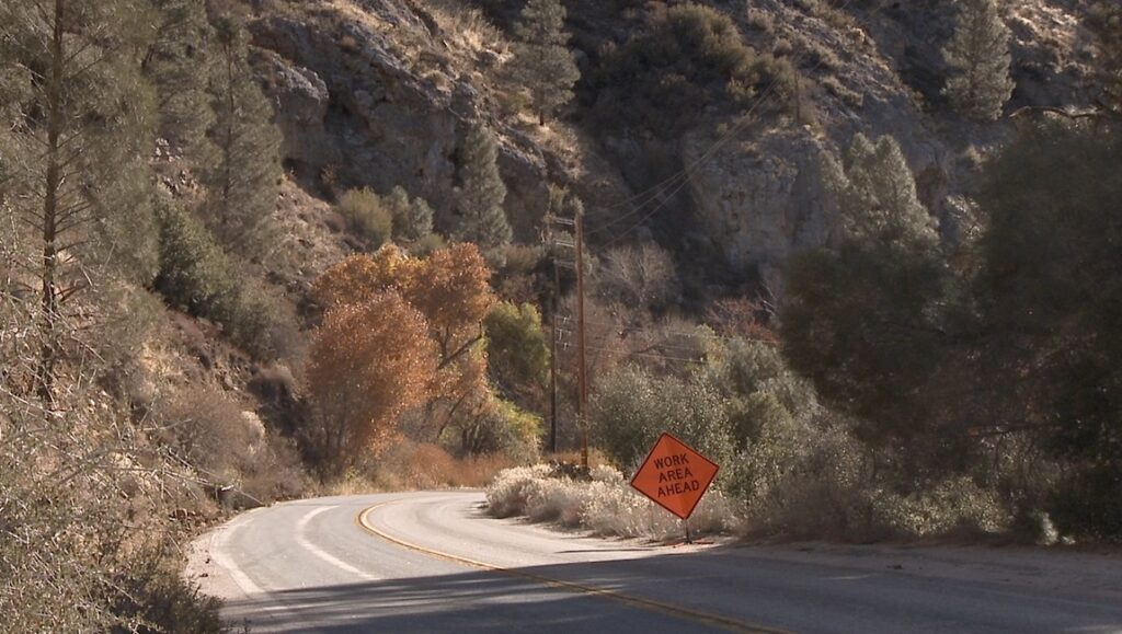 Road winds through Jin Jiang mountain area. Work Area Ahead sign posted. Republic review.