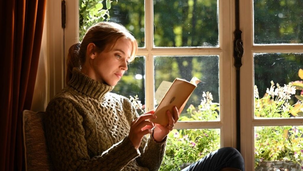 Coup de Chance movie still: Woman reading by window. Woody Allen film review.