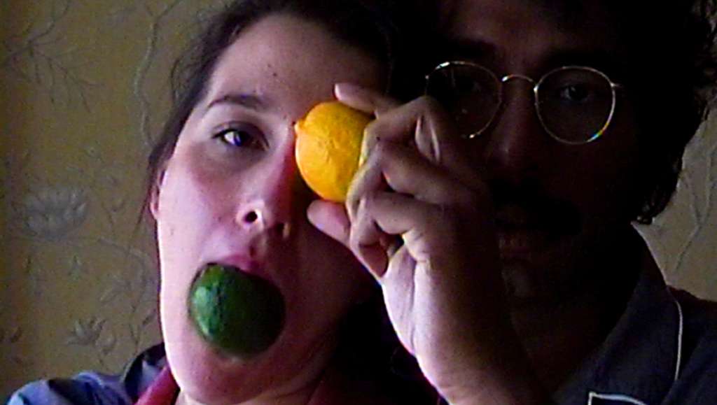 Malqueridas film still: Woman with lime in mouth, man holding lemon to eye. NewStrains review.