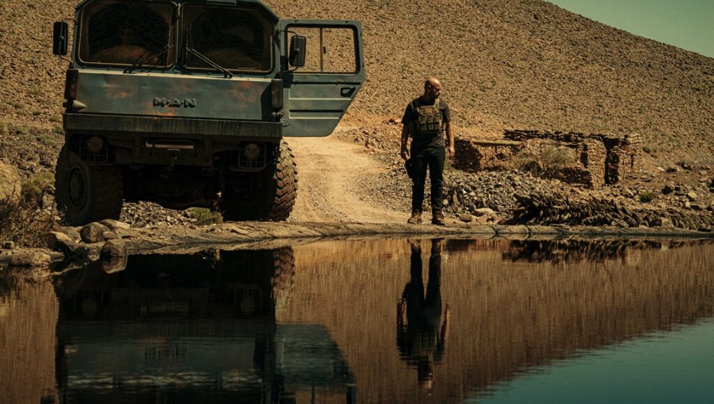The Wages of Fear movie scene. Man near water, truck, desert. Reflection.