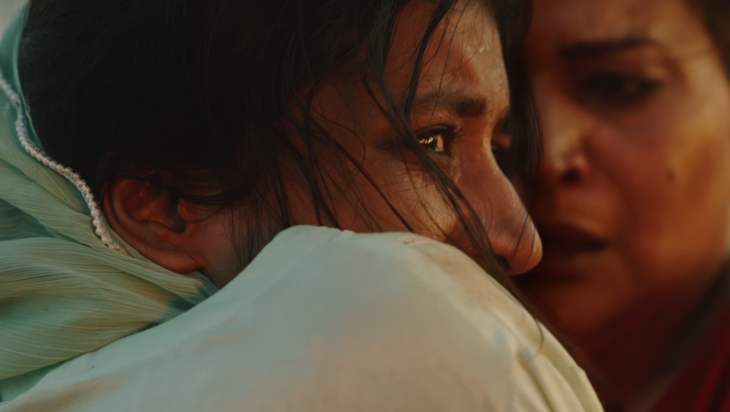 In Flames review: Close-up of two women embracing, one in a headscarf, conveying emotion and connection.