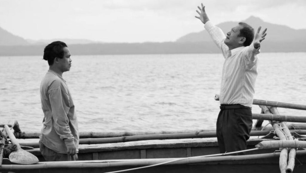 Black and white still from Lav Diaz's When the Waves Are Gone. Two men on a boat. One man has his arms raised.