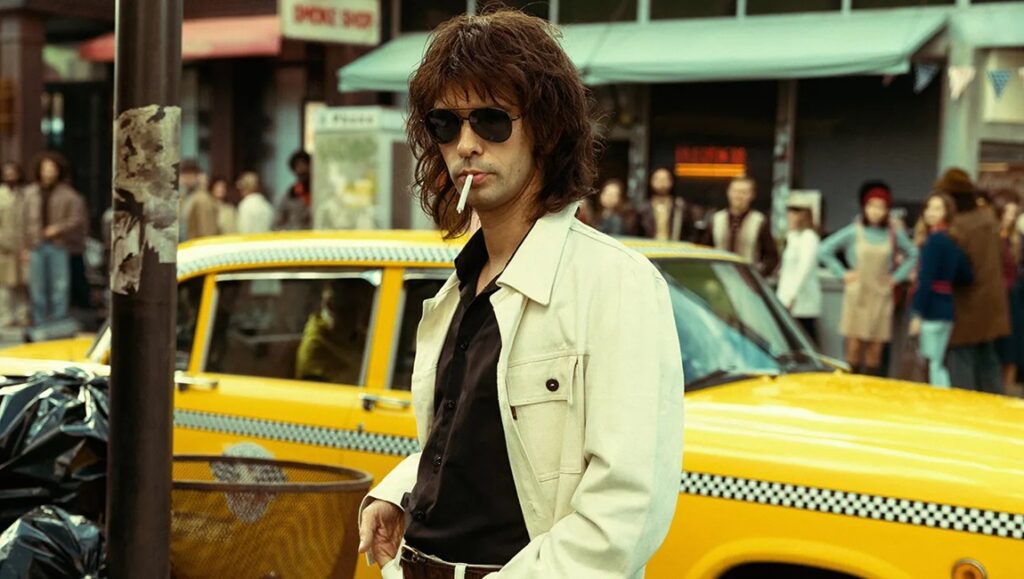 Still from Limonov: The Ballad at Cannes '24. Ben Whishaw as Limonov with a cigarette and yellow taxi.