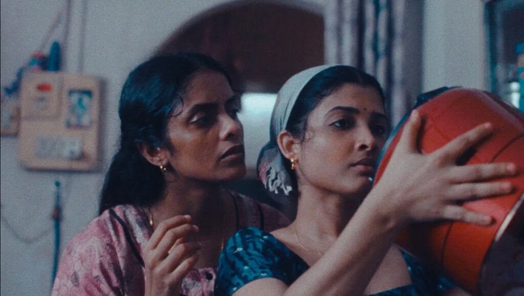 Cannes Film Festival 2024 — Dispatch 4: All We Imagine as Light, The Damned, Motel Destino All We Imagine as Light film still: Two South Asian women indoors, one holding a red object.