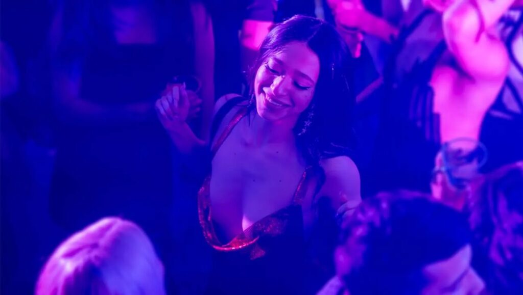 Woman dancing in nightclub with friends. Party scene with blue lighting. Nightlife.