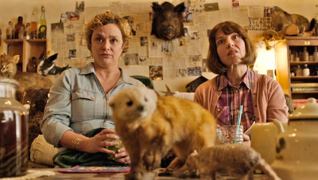 Christmas Eve in Miller's Point film scene. Two women sit among taxidermied animals. Cannes Film Festival 2024.