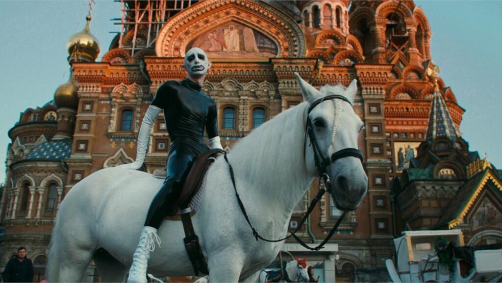 Queendom movie still: Agniia Galdanova on a white horse, Church of the Savior on Spilled Blood in the background.